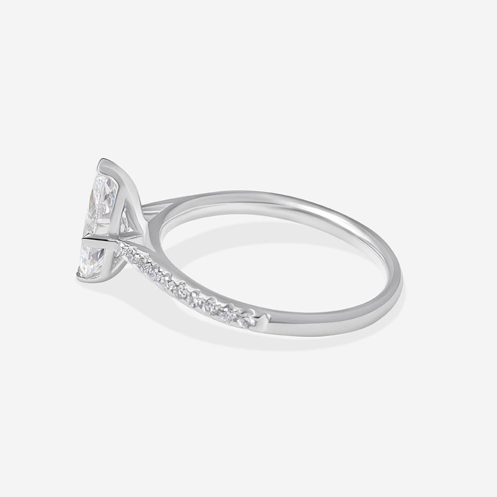 A platinum diamond ring featuring a marquise-cut center stone and pavé-set diamonds along the band.
