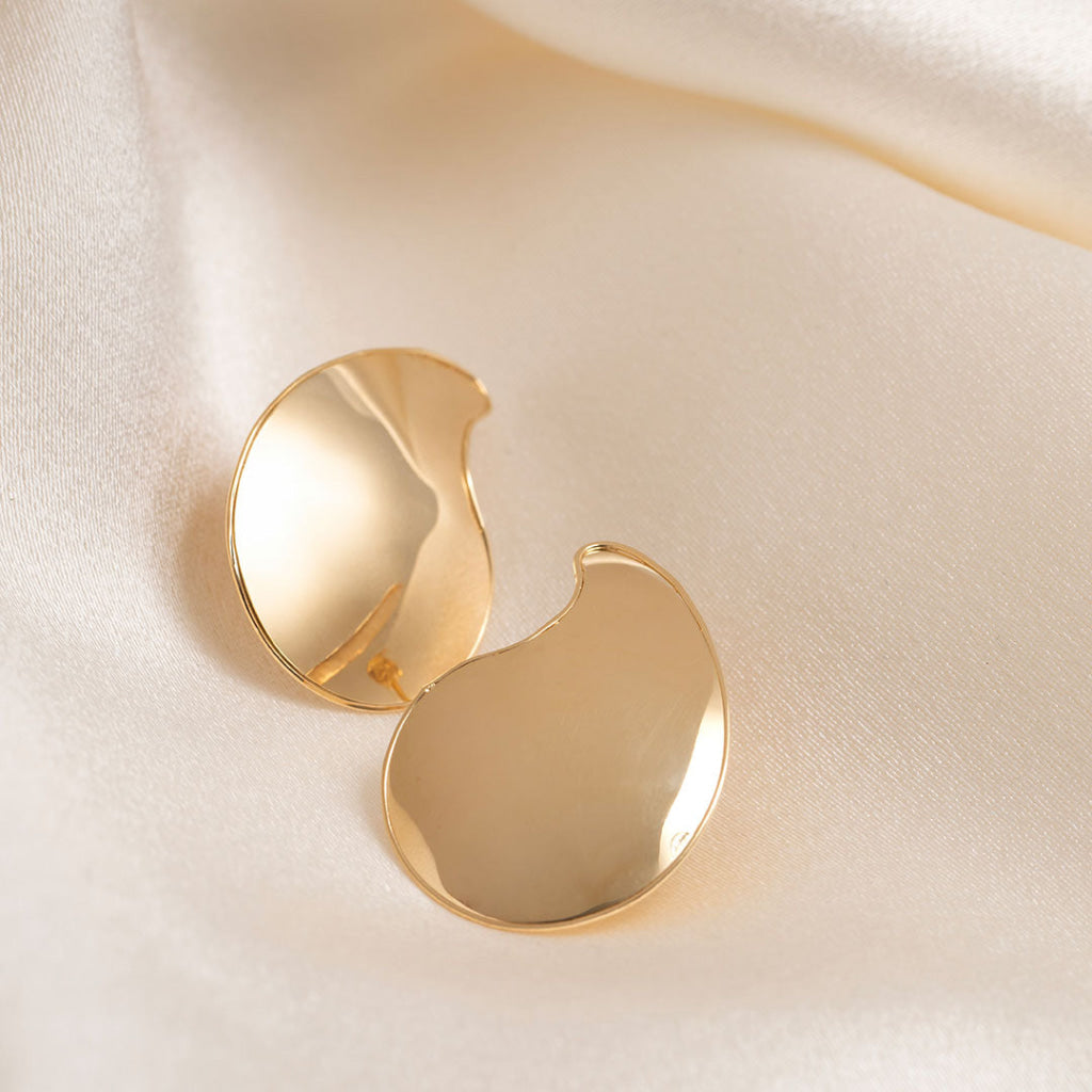 14ct gold abstract shaped earrings on a cream fabric background