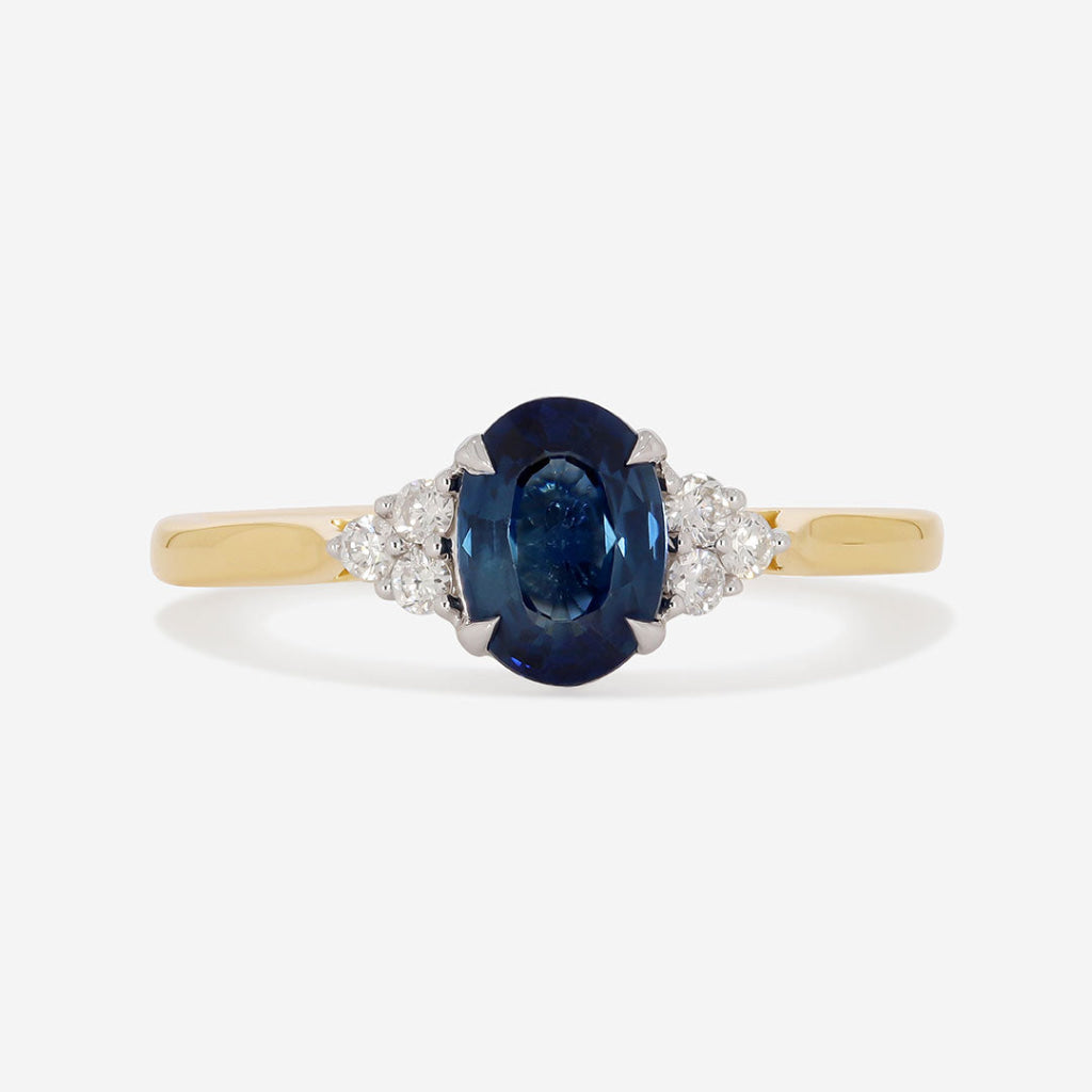 oval sapphire with round side diamonds on white background
