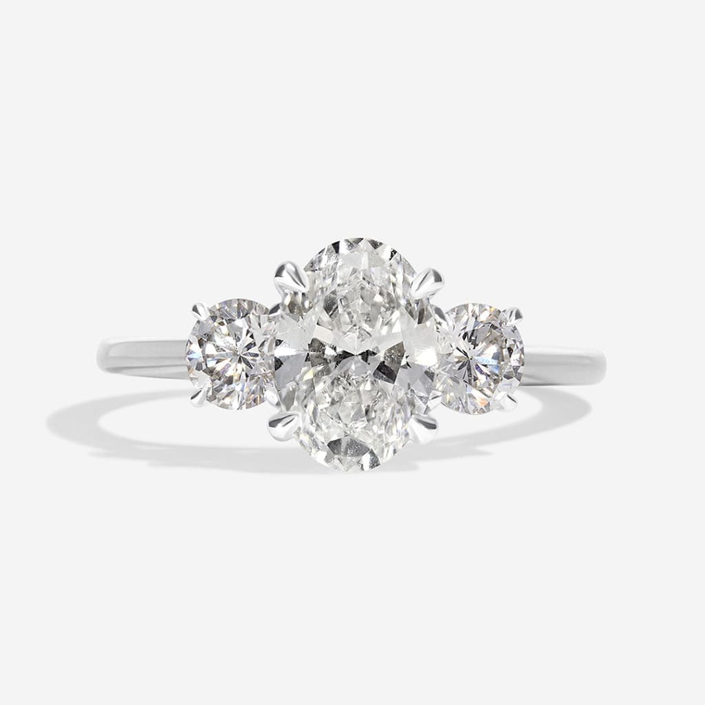 oval three stone engagement ring on white background