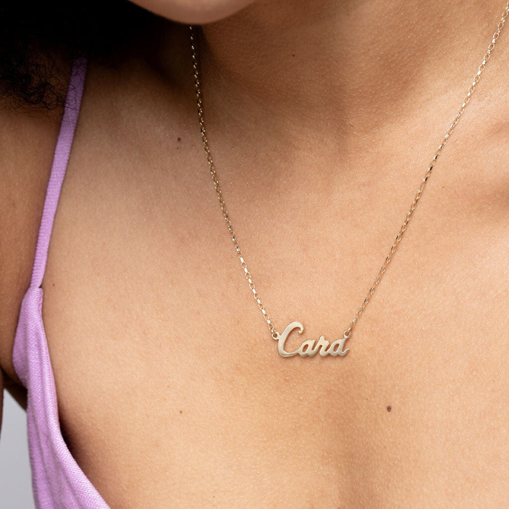 Model wearing a gold name necklace