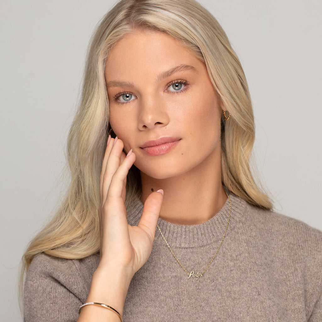 model wearing yellow gold name chain 