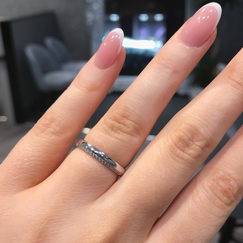Offset diamond wedding ring on woman's hand.
