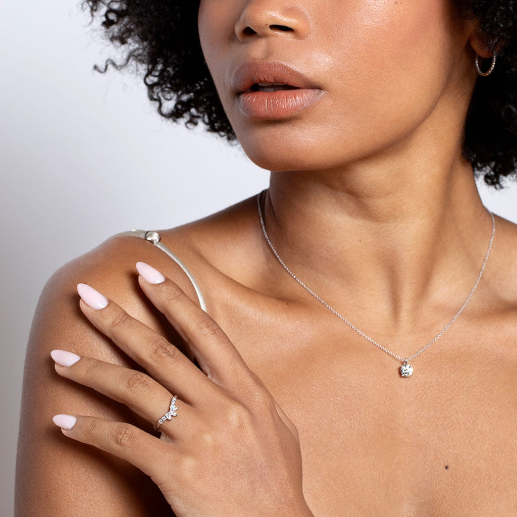 Model hand on shoulder wearing curved diamond band