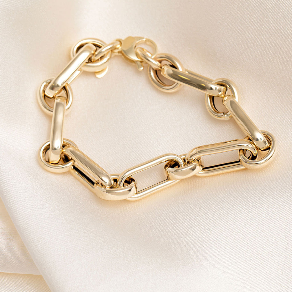 Gold oval and round link bracelet on cream background