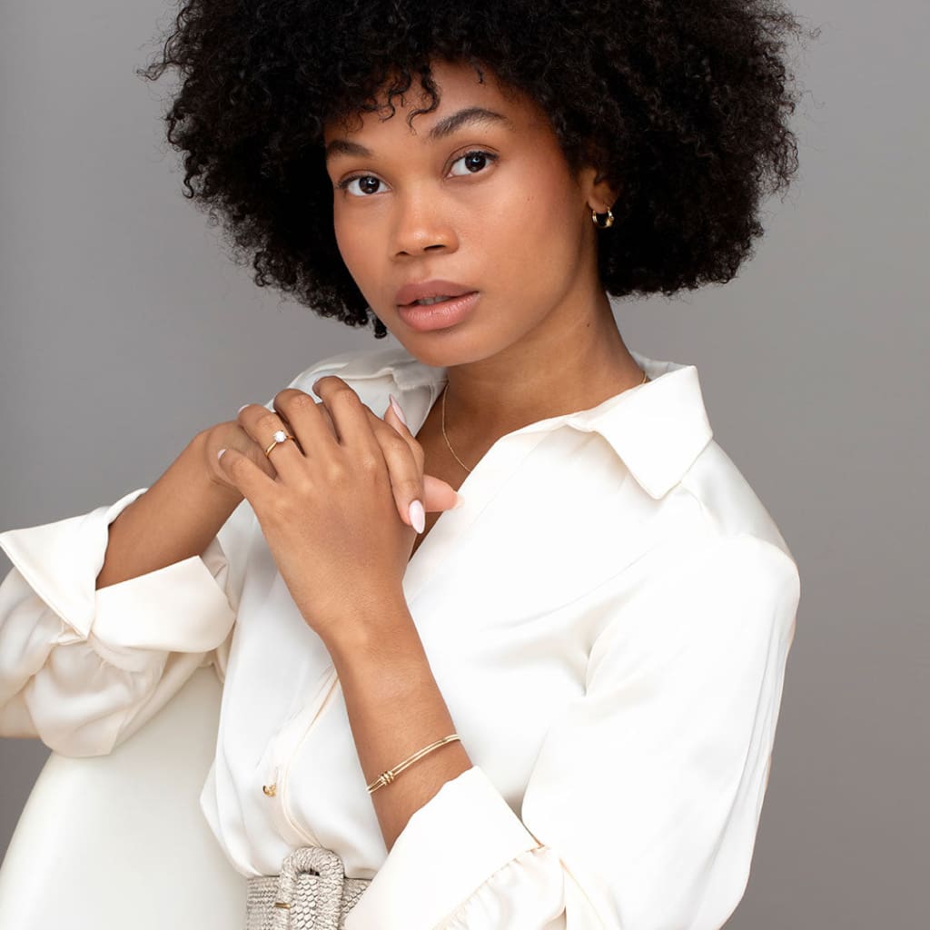 Model sitting wearing Orchid 1ct diamond engagement ring