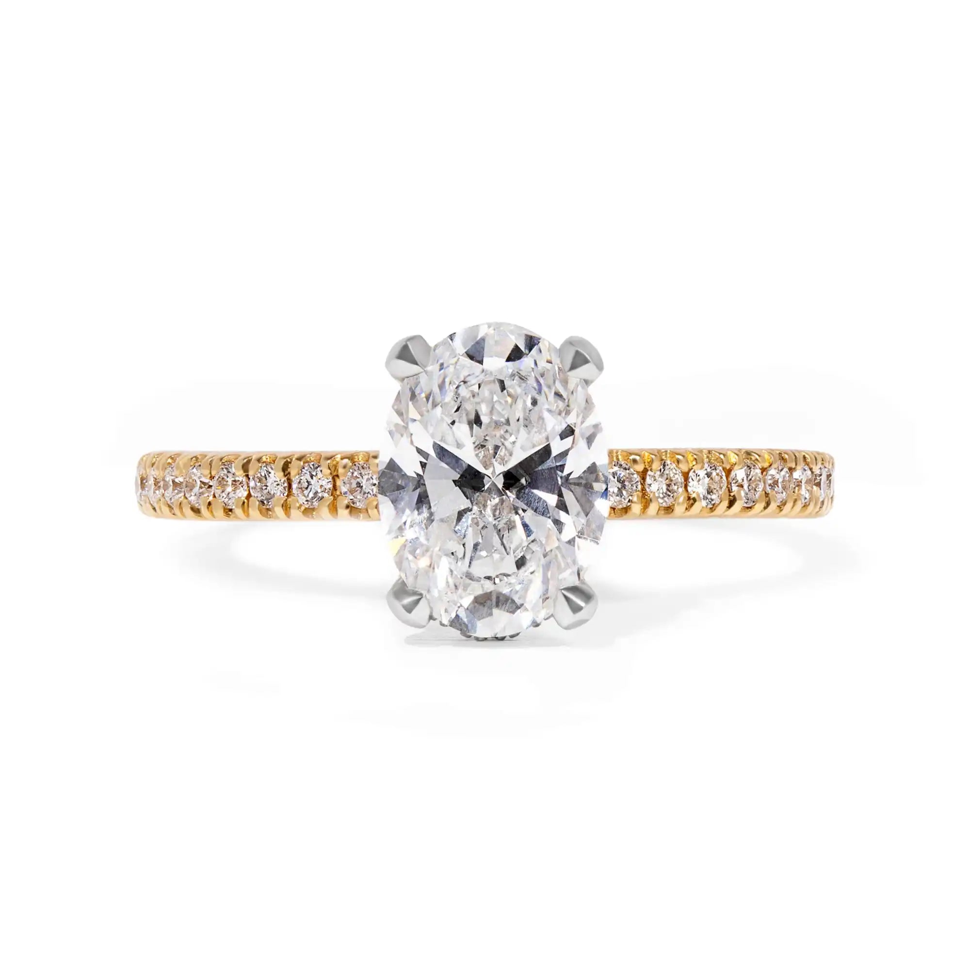 Oval-cut diamond engagement ring with a yellow gold pavé band.