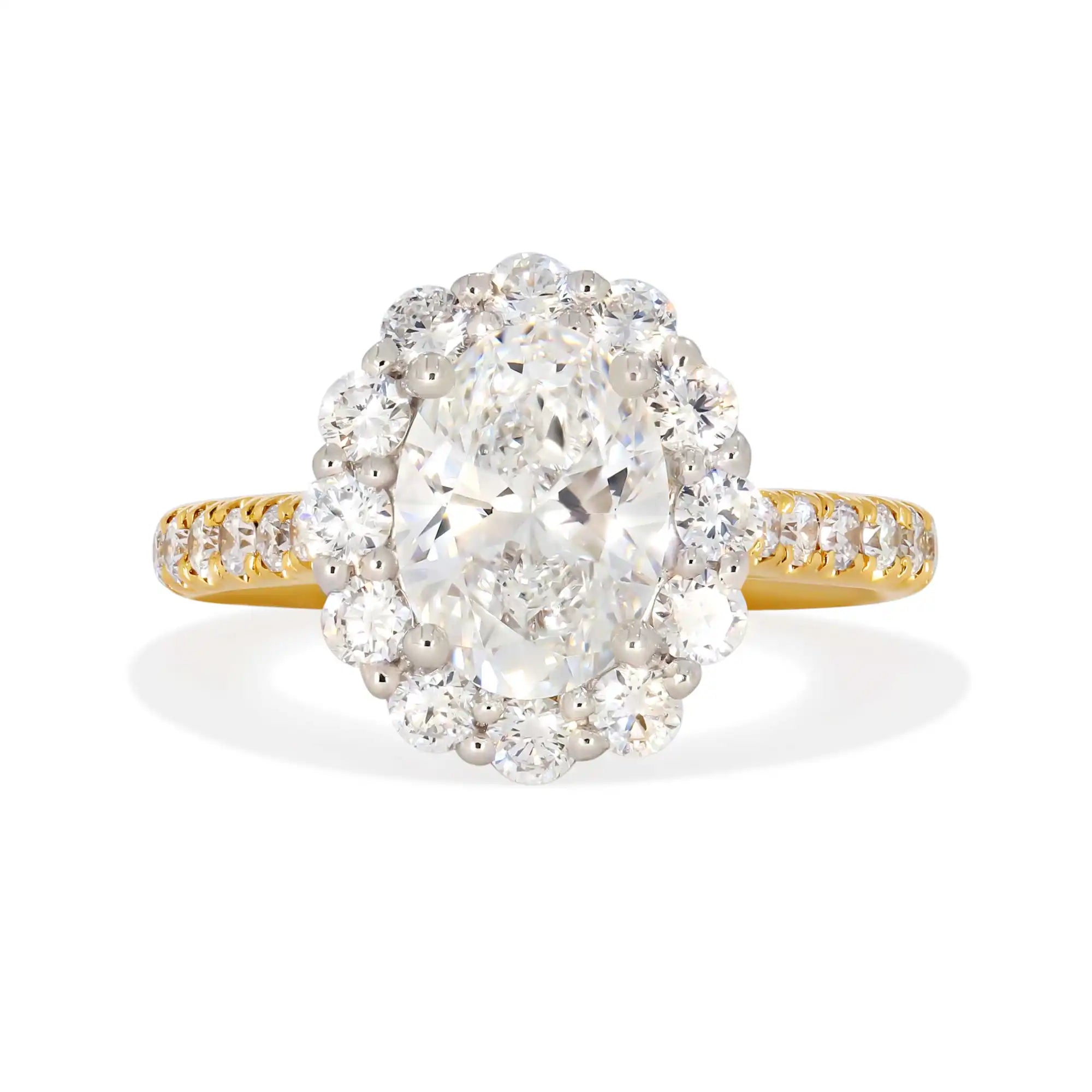 Oval diamond engagement ring with a halo setting and two-tone gold band.