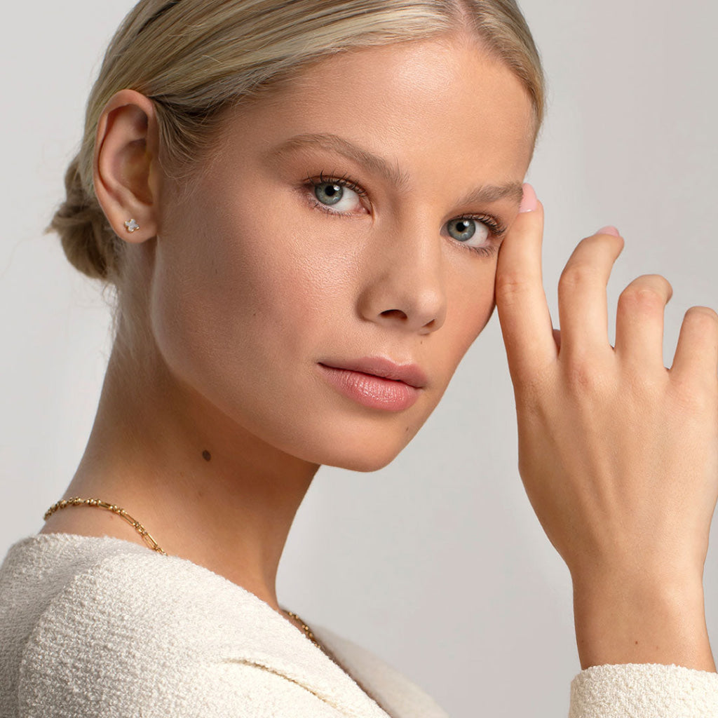 model wearing stud earrings paired with gold chain