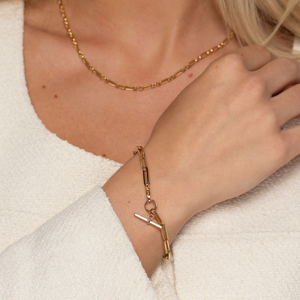 paperlink t bar bracelet paired with gold chain on model