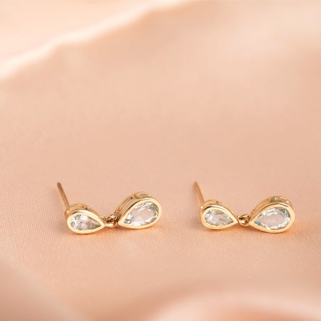 pear aquamarine drop earrings on fabric