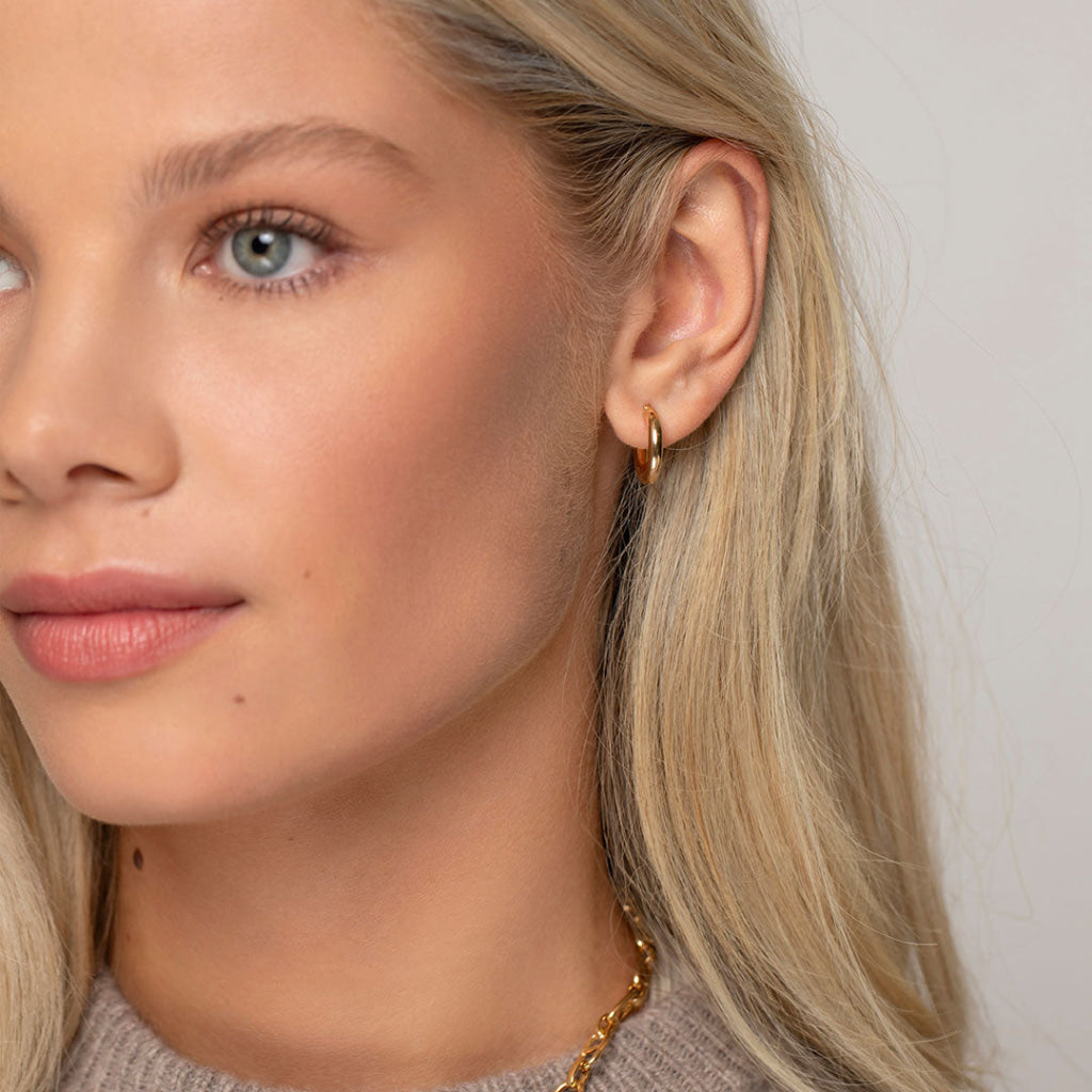 model wearing gold hoops and chain