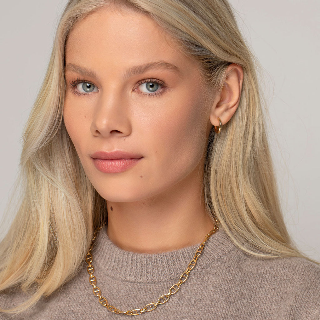 model wearing yellow gold hoops and chain 2