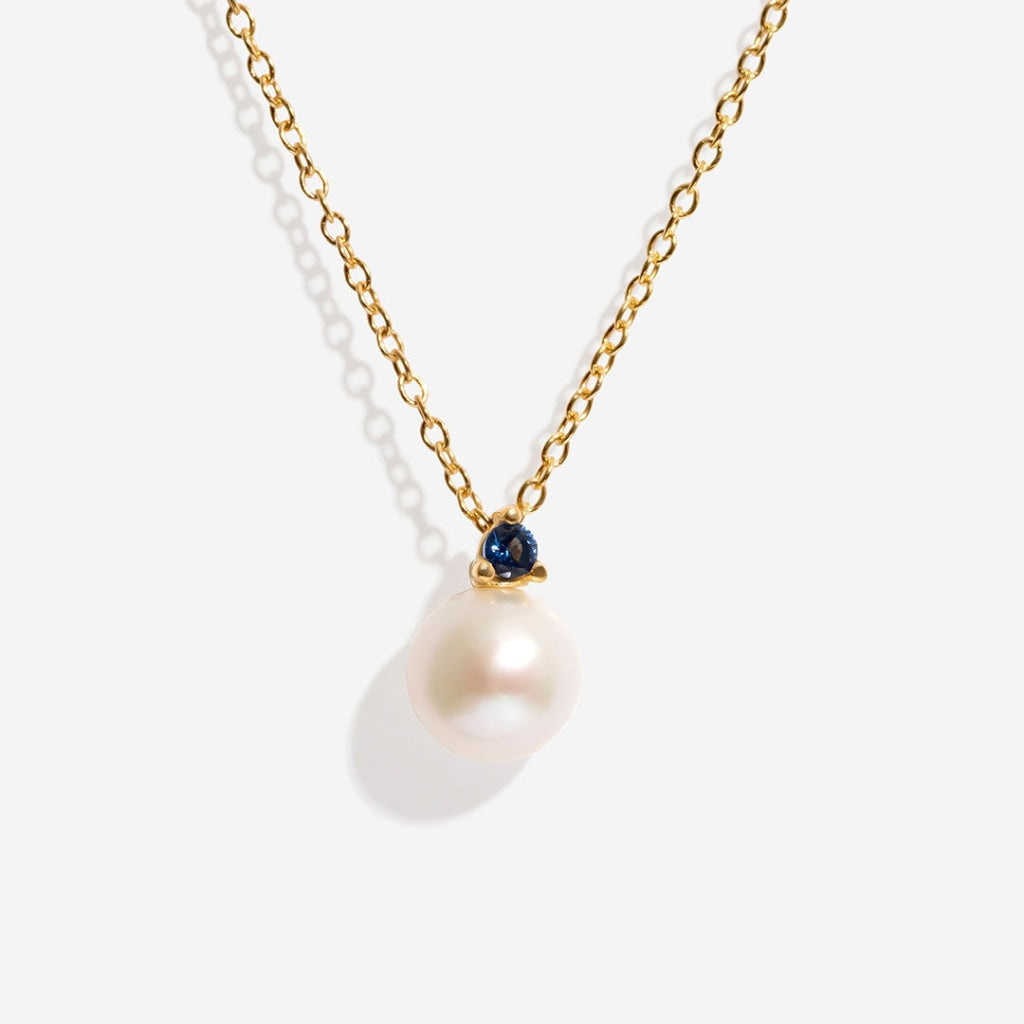 Pearl with blue cz on white background