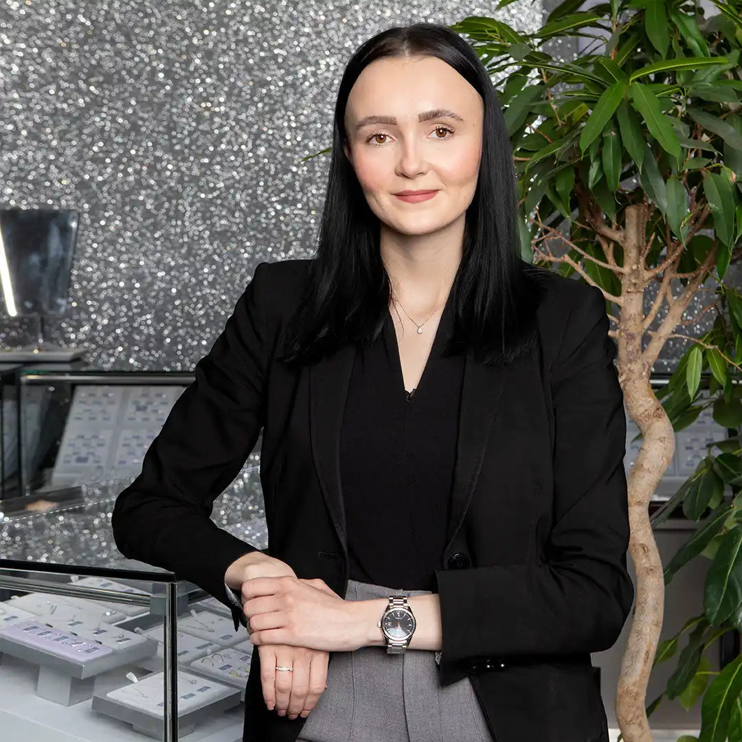 A professional wearing a black blazer and watch in a business portrait.