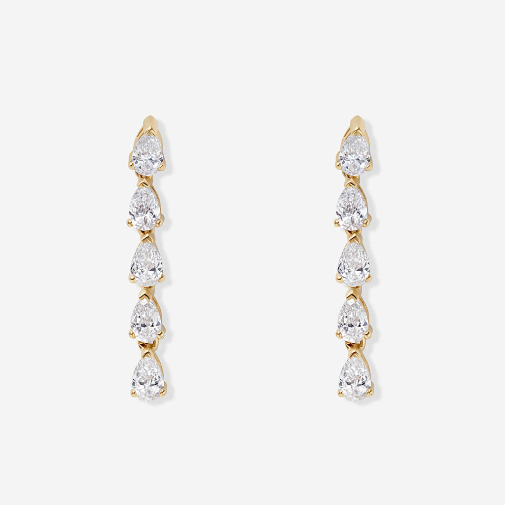 A pair of gold drop earrings featuring a vertical arrangement of five pear-cut diamonds in a claw setting, displayed against a light gray background.