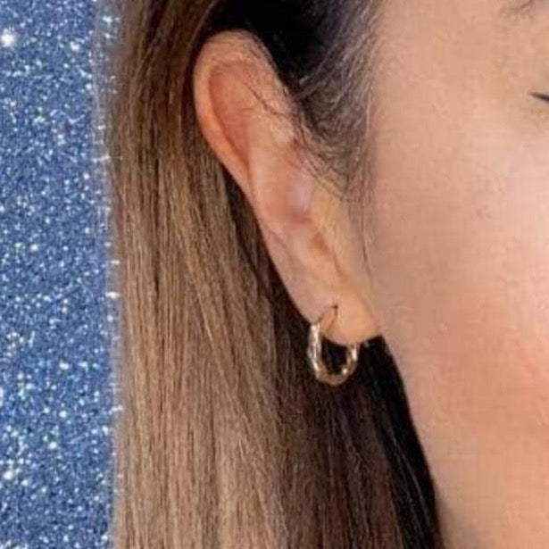 Woman wearing 9ct gold Slim Twist Hoop Earrings 10mm | Gear Jewellers Dublin