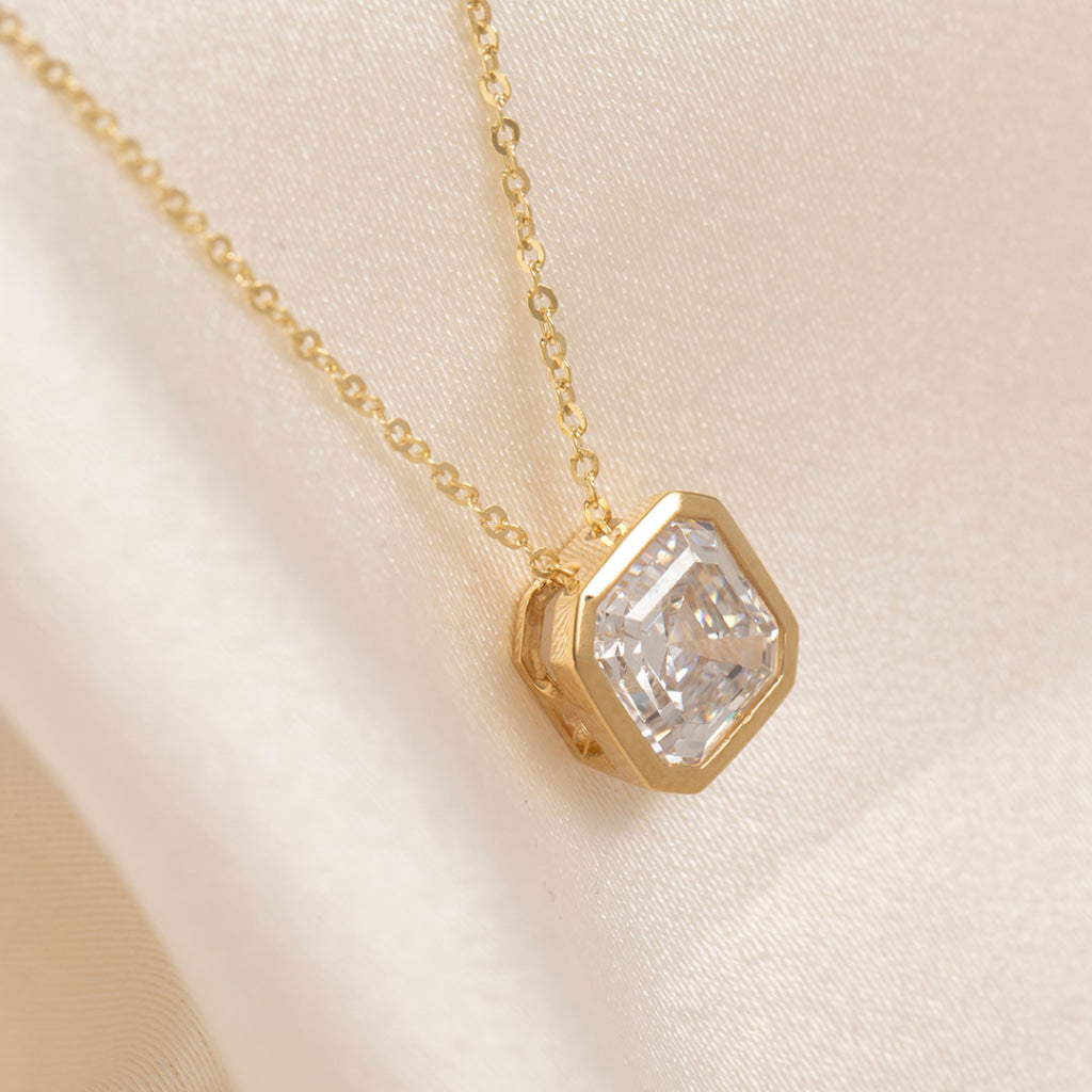 close up of yellow gold pendant on chain