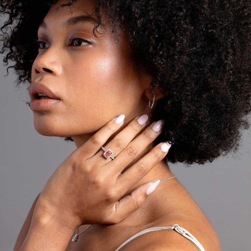 Model touching neck wearing Pink diamond engagement ring