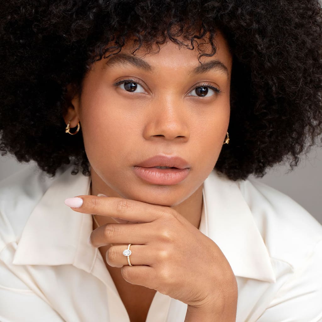 Far shot of model wearing rook oval engagement ring