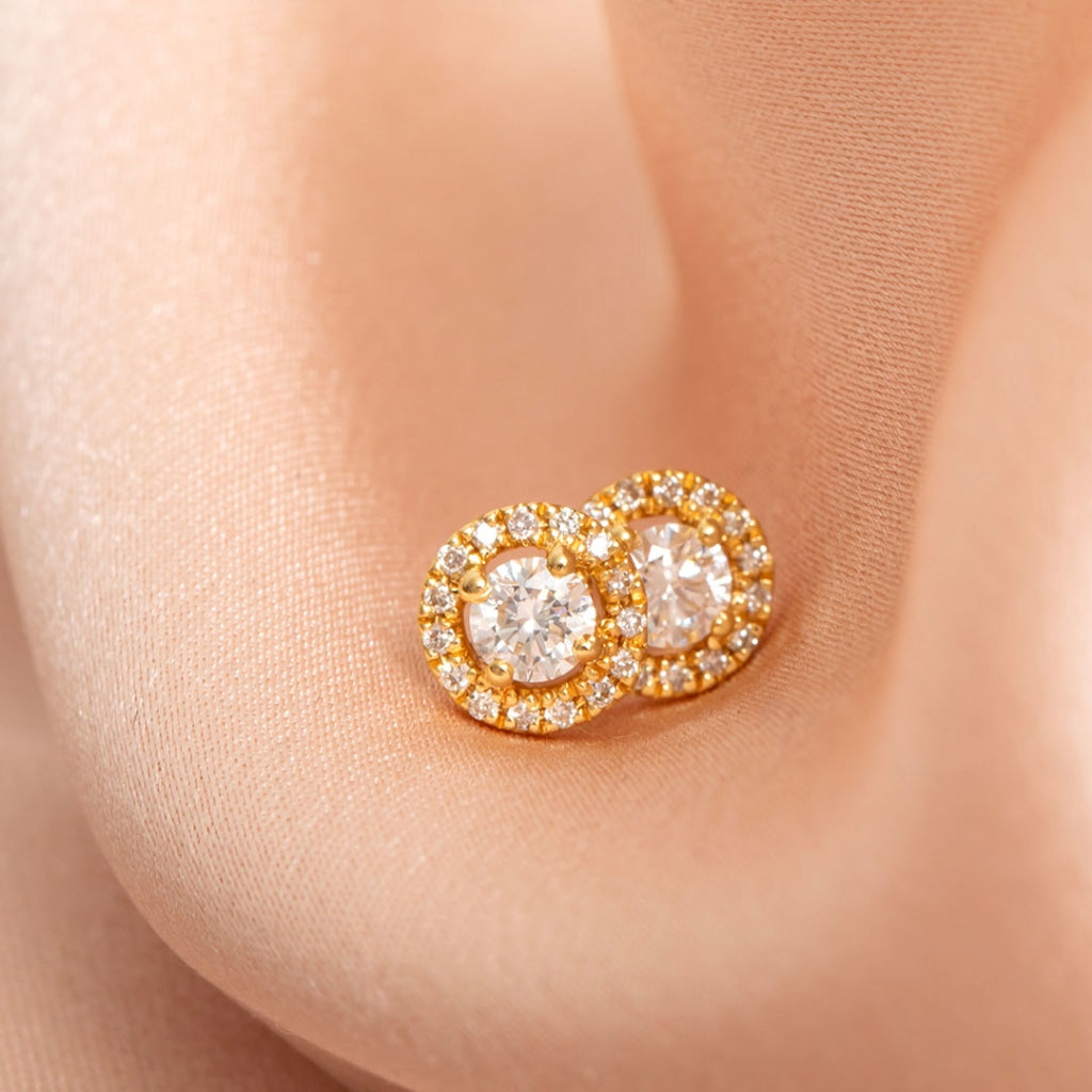 Halo diamond earrings on pink fabric