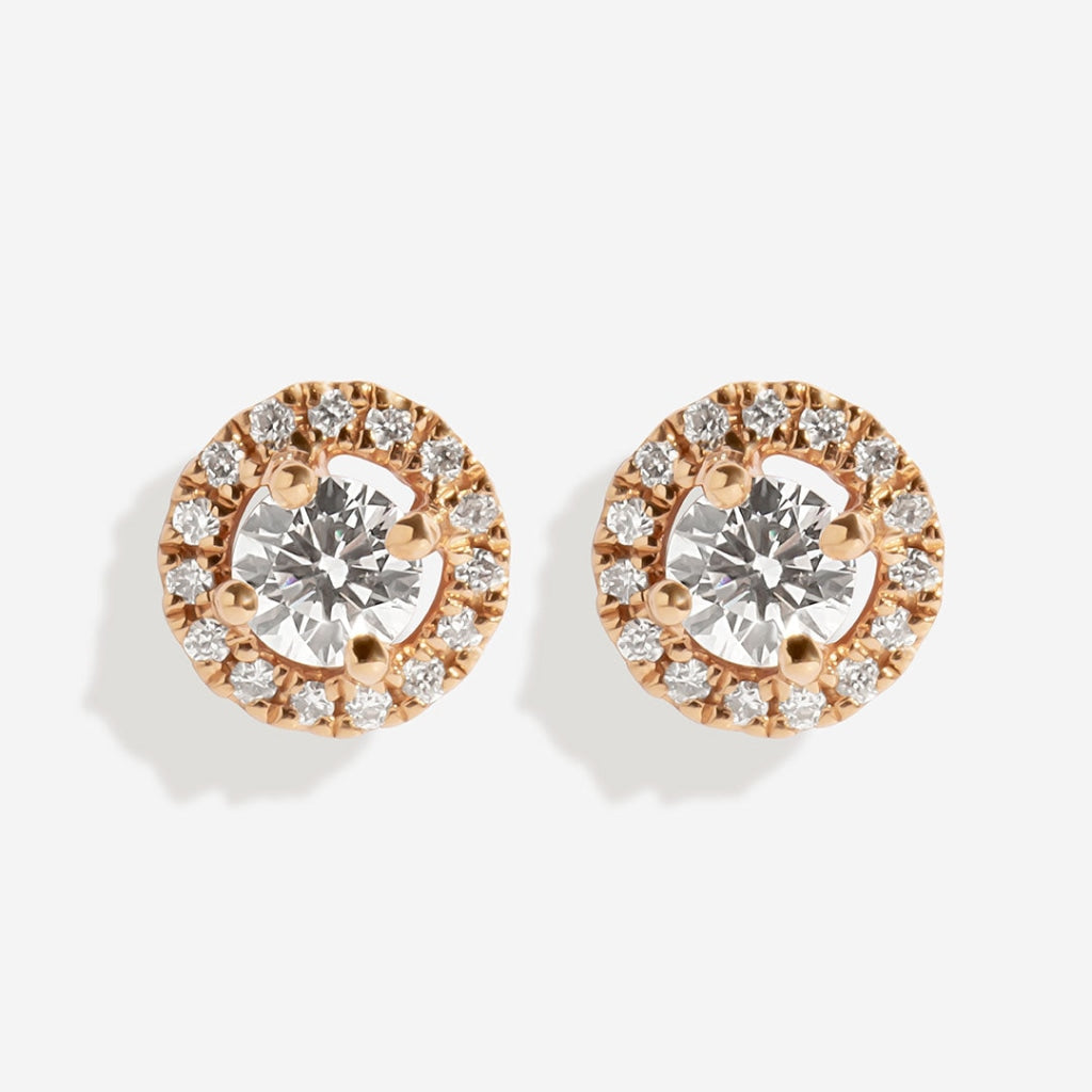 Rose gold diamond earrings on white background