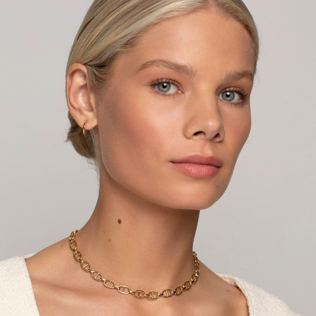 model wearing gold chain and hoop earrings