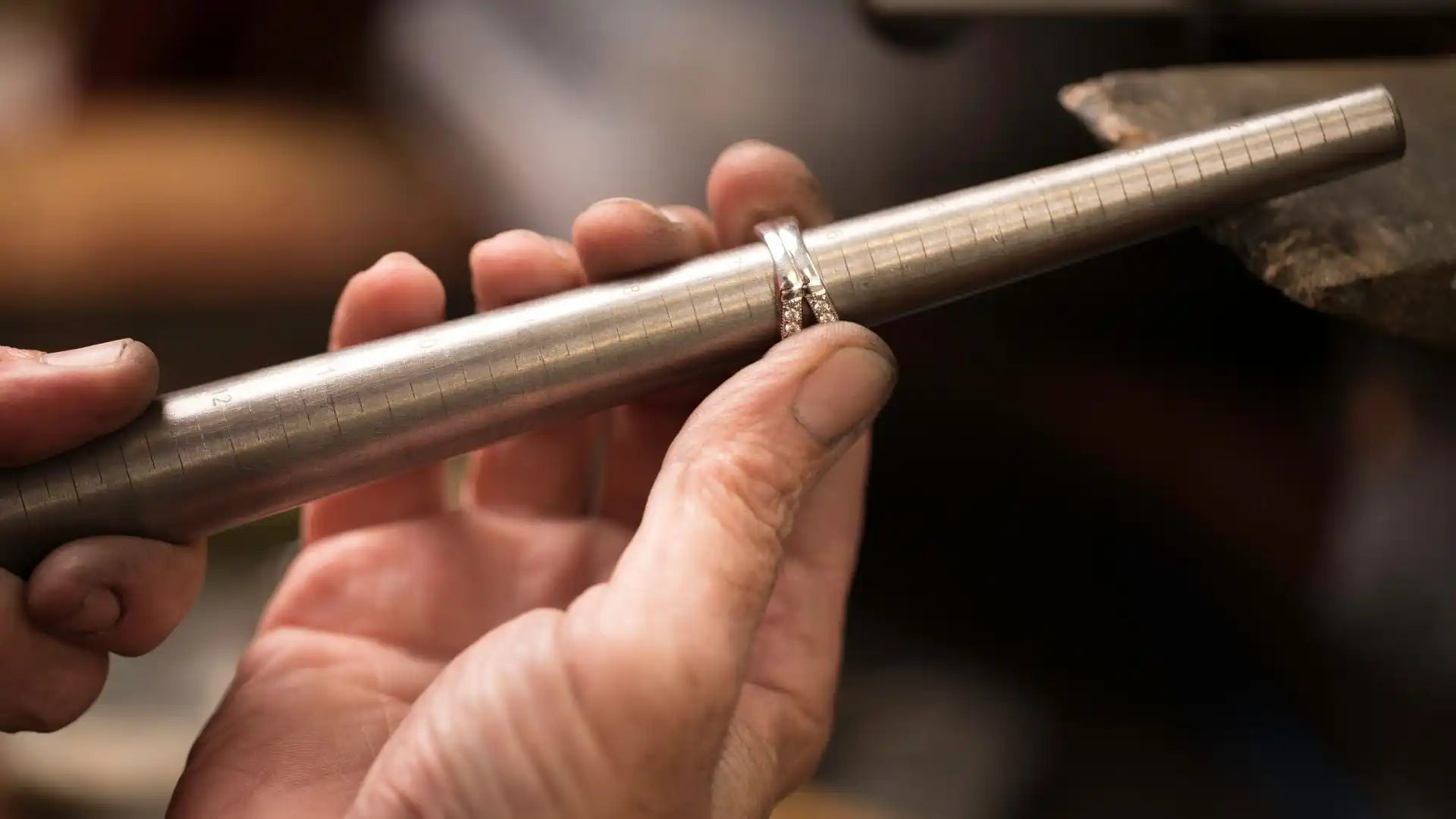 Silver flute being held by hands.