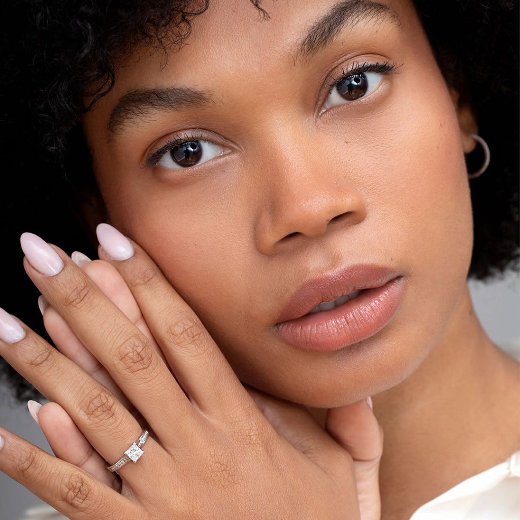 Model with hand to face wearing princess cut engagement ring