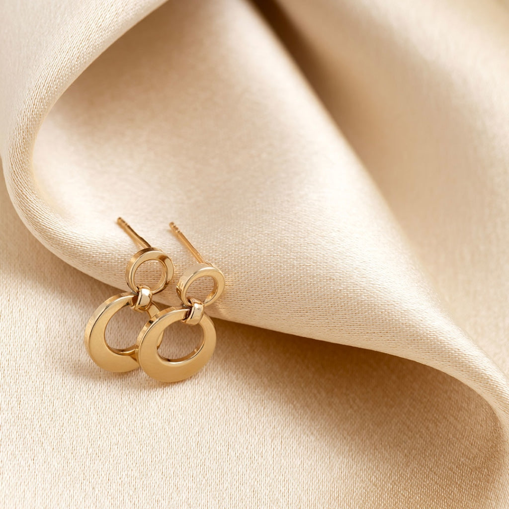yellow gold drop earrings on fabric