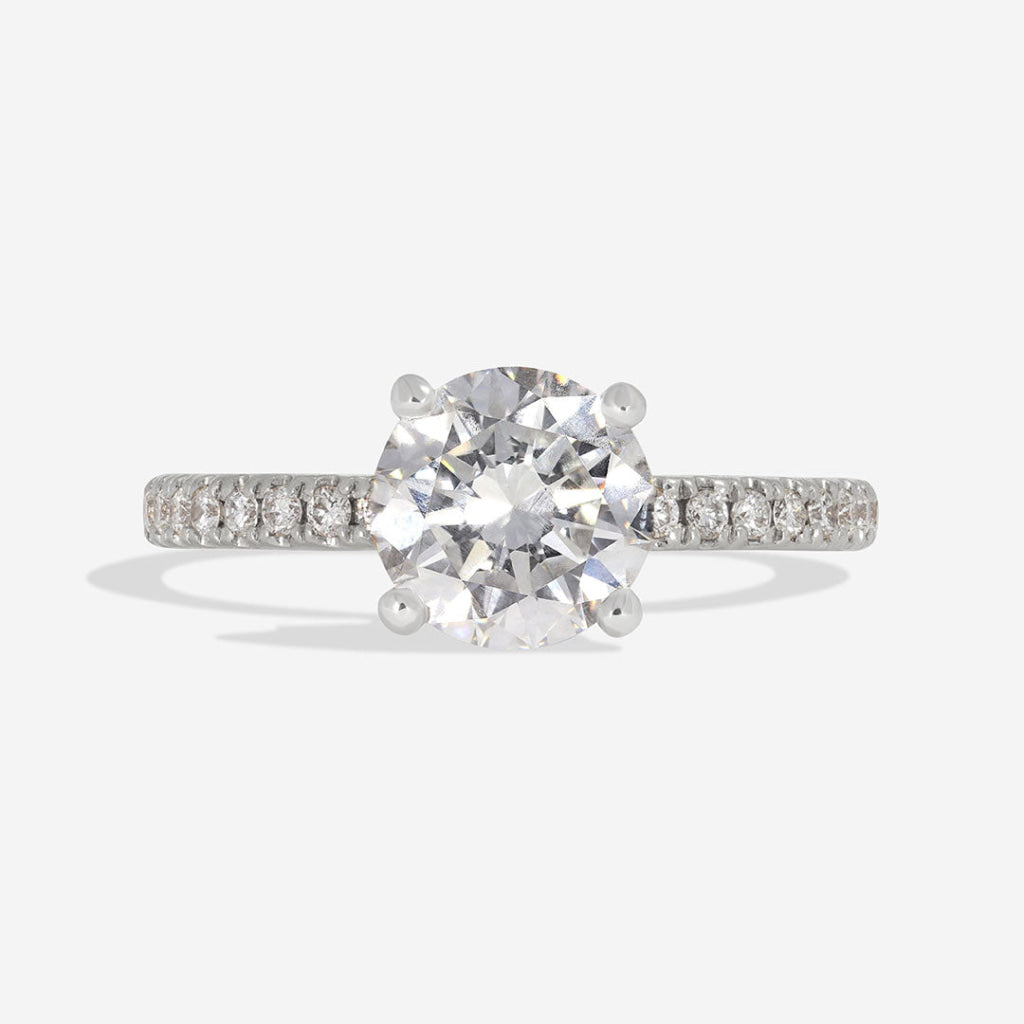 Round solitaire diamond engagement ring with diamond shoulders