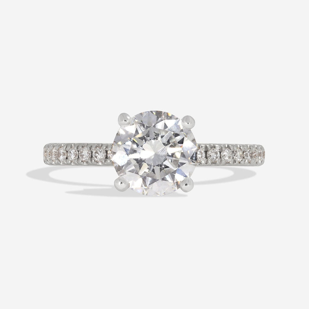 Round solitaire diamond engagement ring with diamond shoulders