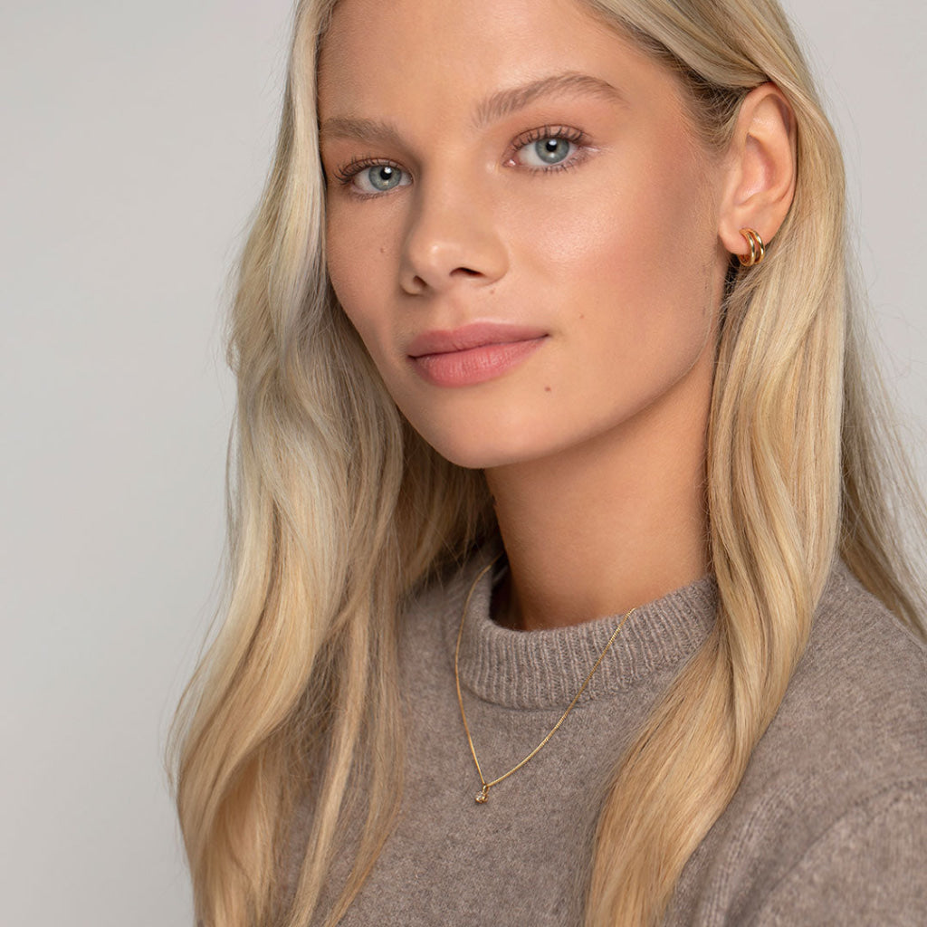 model wearing gold hoops and necklace