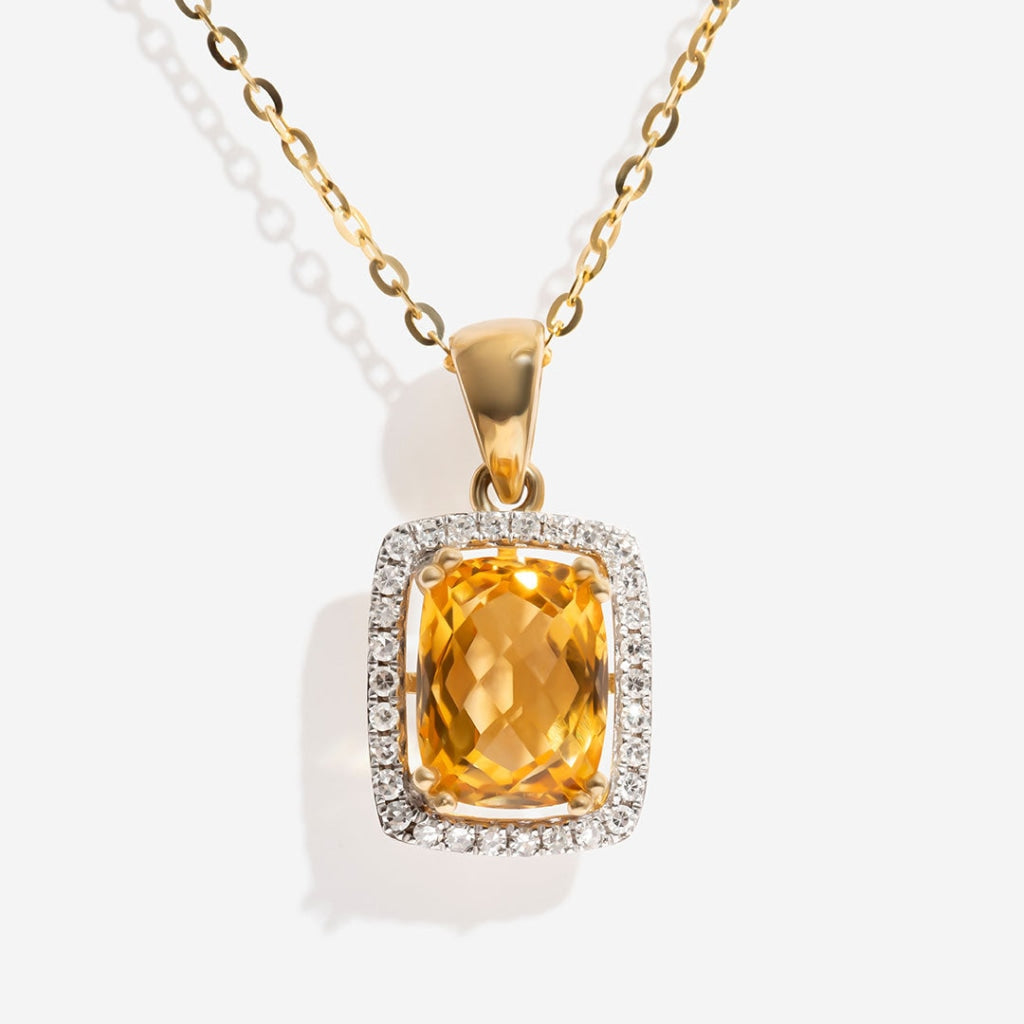 citrine and diamond necklace on white background