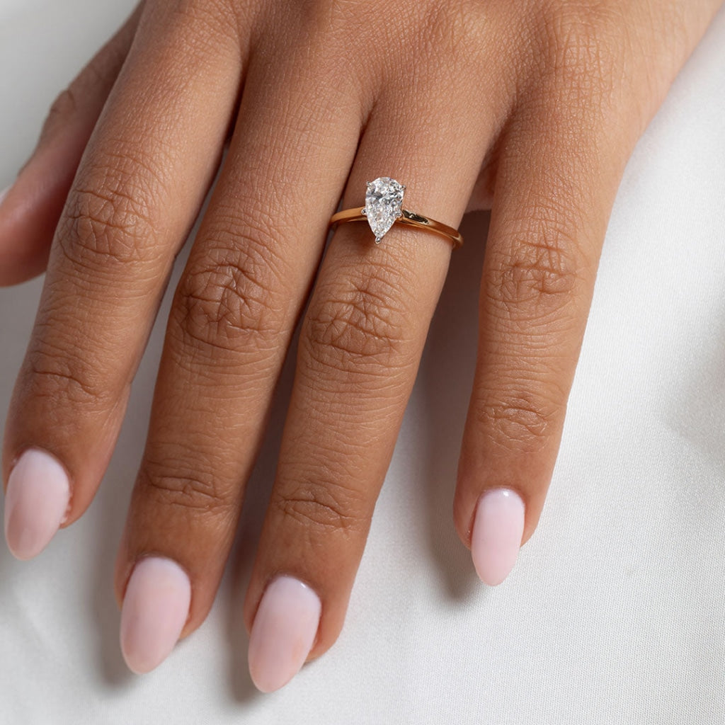 Model's hand wearing pear shape Tolka diamond engagement ring