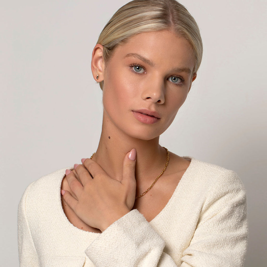 model wearing gemstone earrings and gold necklace