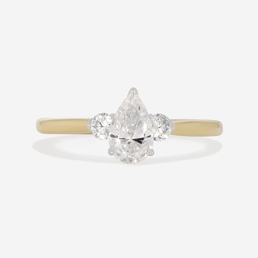 pear cut three stone diamond engagement ring on white background