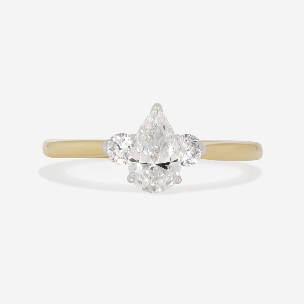 pear cut three stone diamond engagement ring on white background