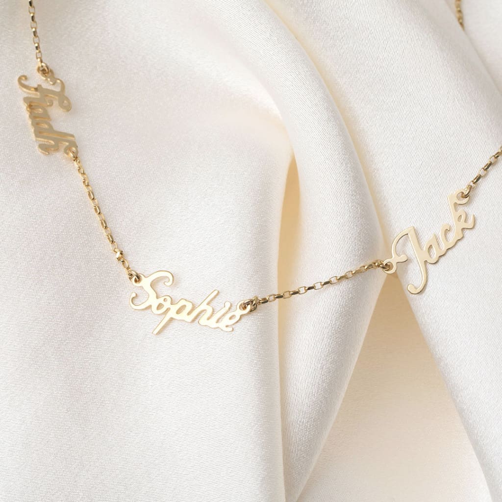 Triple Name chain gold necklace on cloth background