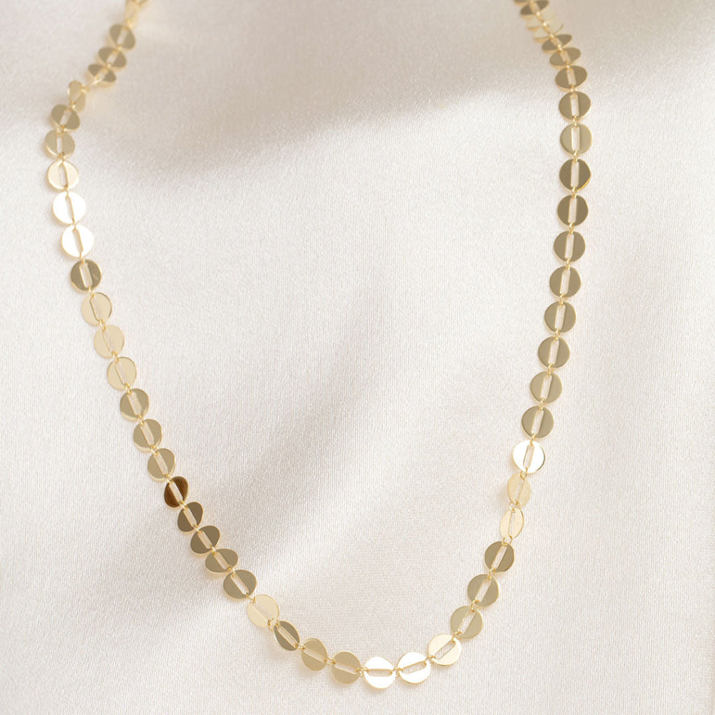 yellow gold link chain on fabric