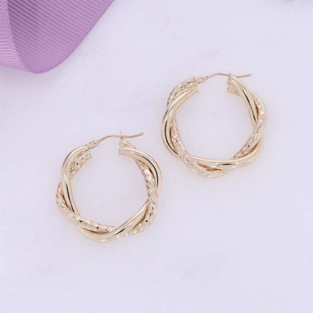 9ct gold 20mm twist hoop earrings beside a purple ribbon