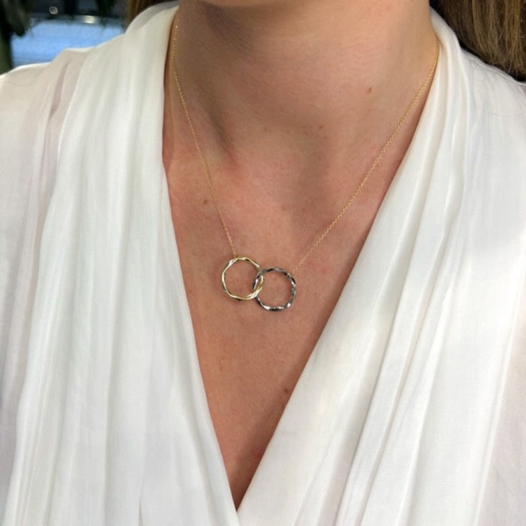 Interlocking Circles gold necklace on models neck